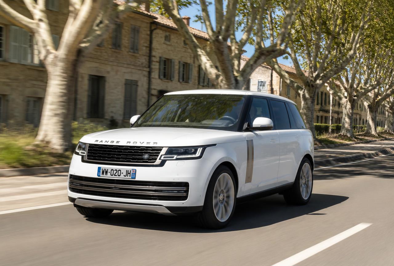 Le SUV blanc remis en état roule au soleil sur une route bordée de platanes